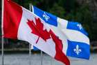 The flag of Canada and the Flag of Quebec at Chicoutimi along the Saguenay River, Quebec, Canada
