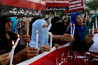 People hold candles during a March 29, 2016 gathering to mourn the victims of suicide bomb attack in Lahore, Pakistan.