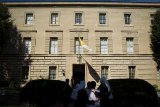 People are seen outside the Vatican Embassy, or apostolic nunciature, in Washington in 2014. A member of the Vatican diplomatic corps serving in Washington has been recalled to the Vatican where he is involved in a criminal investigation involving child pornography, the Vatican said. 