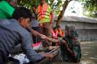 People in Jamalpur, Bangladesh, receive water purifying tablets from volunteers July 21, 2019. Recent flooding from monsoon rains in 28 of the country&#039;s 64 districts affected more than 7 million people, posing serious challenges for Caritas Internationalis and government relief efforts.