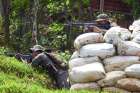 Guatemalan soldiers use a pile of sandbags as a trench as they take part in an operation in Cuilco, Guatemala, July 26, 2024, to protect Mexican citizens who fled to neighboring Guatemala amid armed clashes between criminal groups fighting over drug trafficking routes and other crimes. 