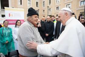 Pope Francis greets a man after making a surprise visit Nov. 16 to the medical tents set up just outside St. Peter’s Square at the Vatican. Volunteer doctors, nurses and technicians were offering medical exams, tests and treatment to the poor throughout the week leading up to the World Day of the Poor, Nov. 19.