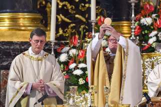 Cardinal Rainer Maria Woelki of Cologne, Germany, and Cardinal Reinhard Marx of Munich elevate the Eucharist during Mass in the cathedral in Fulda, Germany, Sept. 23, 2014.