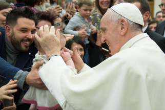 Pope Francis greets a baby during an audience with Italian nurses in Paul VI hall at the Vatican March 3.