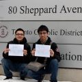 Chinese students Hans Zhang (left) and Alex Zhao hold signs reading “Hi Mom,” one in English and the other in Mandarin, during the Toronto Catholic District School Board’s first International Students Orientation Day.