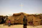 People from South Sudan stand near a tent used as a church at a railway station camp, where they have spent the last four years, in Khartoum on May 11, 2014. 