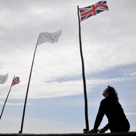 A man raises Olympic and British flags outside his hotel in Sennen near Lands End in Cornwall in southwest England May 17. In advance of the 2012 Summer Olympics, a coalition of U.S. and U.K. investors including Mercy Investment Services and NGOs have co me together to call on corporations to strengthen their focus against human trafficking and modern-day slavery. The games take place in London from July 27 to Aug. 12.