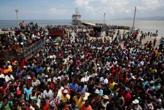 People in Jeremie, Haiti, wait for relief to be unloaded from a Dutch navy ship Oct. 16.