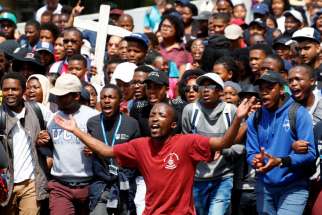 Students from the University of Cape Town, South Africa, sing during an Oct. 5 protest demanding free tertiary education. As students and police clash at South African universities, with many campuses closed because of protests against fee increases, Catholic students called on the government to increase its education budget.