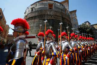 In this 2014 file photo, recruits of the Vatican&#039;s Swiss Guard march in front of the tower of the Institute for Works of Religion, often referred to as the Vatican bank.