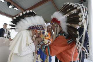 Pope Francis kisses the hand of an Indigenous leader during a meeting with First Nations, Métis and Inuit communities in 2022.