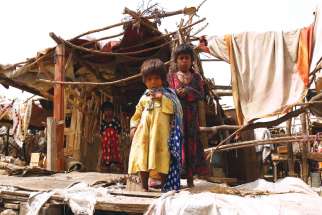 Pakistani children stand outside their makeshift home near Karachi. 