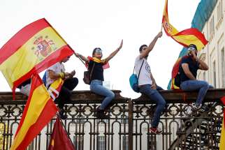 People wave Spanish flags during an Oct. 8 demonstration organized by the Catalan Civil Society organization in Barcelona, Spain.