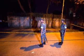 Bangladeshi security officials in Dhaka stand close to the spot where Tavella Cesare, an Italian aid worker, was killed Sept. 28, the previous day. Unknown assailants also shot an Italian priest in northern Bangladesh Nov. 18 