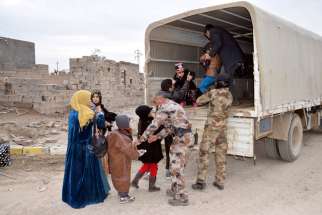 Iraqi soldiers evacuate families from Ramadi, Iraq, Feb. 3, after the city was recently recaptured by Iraqi forces. A European bishops&#039; commission has welcomed a move by the European Parliament to classify atrocities and religious cleansing by the Islamic State as genocide. 