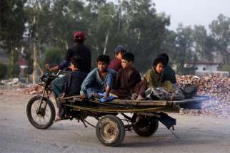 Boys from an Afghan refugee family ride on a motorcycle cart as they head to search for recyclables in Lahore, Pakistan, June 20, 2019. The Vatican said Pope Francis will celebrate Mass in St. Peter&#039;s Basilica July 8 with migrants, refugees and volunteer rescue teams.