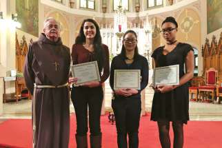 Franciscan Fr. Damian MacPherson, left, stands with the winners of the 14th annual Friar’s Student Writing Award. From left to right, Sabrina Quartarone (third place), Jessica Nguyen (first place) and Ruthann Lemonius (second place).