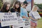 Volunteers for 40 Days for Life praying silently while holding signs calling for the end of abortion at a campaign vigil.