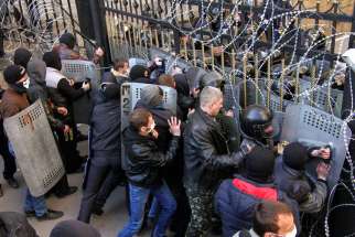  Pro-Russia protesters scuffle with the police at the regional government building in Donetsk, Ukraine, April 6. A Ukrainian Catholic bishop has warned his church could lose its legal status under Russian rule, and pledged to use “all possible means in th e international arena” to defend it. 