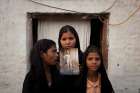 The daughters of Asia Bibi, a Catholic accused of blasphemy, pose in 2010 with an image of their mother while standing outside their residence in Sheikhupura, Pakistan. The Oct. 31 acquittal of Bibi is being challenged in the country&#039;s Supreme Court, according to her husband. 