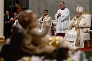 With a statue of the baby Jesus in the foreground, Pope Francis presides over the Christmas Mass at Night in St. Peter&#039;s Basilica at the Vatican Dec. 24, 2024.