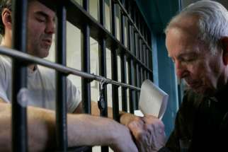 A priest prays with death-row inmate in 2008 file photo.