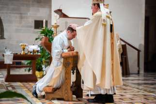 Archbishop Allen H. Vigneron of Detroit lays his hands on Father Matthew Hood to ordain him to the priesthood Aug. 17, 2020, at the Cathedral of the Most Blessed Sacrament. Father Hood, a graduate of Sacred Heart Major Seminary, was originally ordained in 2017.