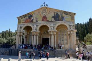 Tourists walk outside the Church of All Nations at the foot of the Mount of Olives in Jerusalem March 28. Pope Francis will meet with priests and seminarians in the church during his pilgrimage to the Holy Land in May.