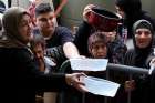 Displaced people reach out for food cooked by a charity kitchen in downtown Beirut Oct. 10, 2024, amid ongoing hostilities between Hezbollah and Israeli forces.