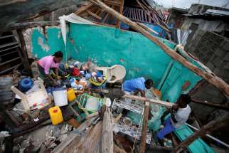 Residents salvage items from their destroyed home Oct. 5 after Hurricane Matthew swept through Les Cayes, Haiti.
