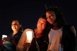 Masses and prayer services have been taking place across the city since the shooting. Women weep during a candlelight vigil Oct. 3 in memory of the victims of a mass shooting along the Las Vegas Strip. 