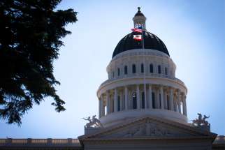 U.S. and California flags fly in front of the dome of the California Capitol in Sacramento May 9, 2019.