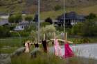 Children’s red dresses hang on stakes near the grounds of the former Kamloops Indian Residential School June 6, 2021.