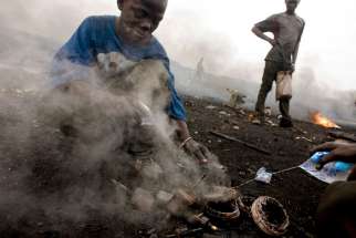 In this Aug. 8, 2008, file photo, a boy salvages copper found inside a burned motor in Accra, Ghana