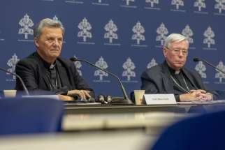 Cardinal Mario Grech, secretary-general of the synod, and Cardinal Jean-Claude Hollerich, relator general of the synod, attend a news conference at the Vatican Sept. 16, 2024, to present the calendar and list of participants for the second session of the ongoing Synod of Bishops.