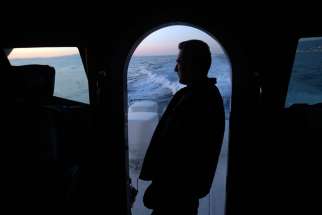 A sailor from the Greek Coast Guard monitors the Mediterranean Sea for undocumented migrants Sept. 24, 2014