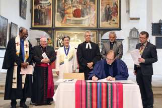 Reformed, Catholic, Lutheran and Methodist leaders look on in St. Mary&#039;s City Church in Wittenberg, Germany, as the Rev. Chris Ferguson, World Communion of Reformed Churches general secretary, signs the declaration expressing Reformed churches&#039; support for the Catholic-Lutheran Joint Declaration on the Doctrine of Justification.