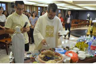 Msgr. Jesus-Norriel Bandojo, a priest in the the Office of Exorcism of the Manila Archdiocese in the Philippines, gives a blessing and says a prayer of deliverance over &quot;sacramentals&quot; in late October at the archdiocese offices&#039; chapel to ward off the pos sibility of evil forces attaching themselves to the religious items.