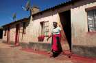 A woman walks out of her family home in Harare, Zimbabwe, May 9, 2020, during the COVID-19 pandemic. Church officials and experts say domestic violence in Africa is rising during government-enforced measures to fight COVID-19.