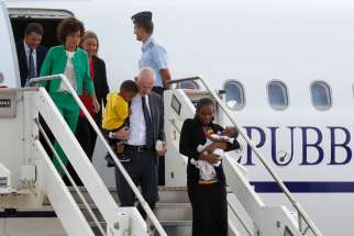 Meriam Ibrahim of Sudan carries one of her children as she arrives with Lapo Pistelli, Italy&#039;s vice minister for foreign affairs, holding her other child, Italy&#039;s Prime Minister Matteo Renzi, left, and his wife Agnese, second from left in green, after landing at a Rome airport July 24. The Sudanese woman, who was spared a death sentence for converting from Islam to Christianity and then was barred from leaving Sudan, left Italy on July 31 on a flight for the United States where she plans to build a new life.