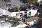 Recovery teams examine the charred remains of a two-story converted warehouse Dec. 4 in Oakland, Calif. A blaze at the building Dec. 2 claimed the lives of at least 33 people. 