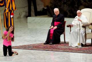 Clelia Manfellotti, a 10-year-old autistic girl from Naples, Italy, smiles as Pope Francis leads his general audience in Paul VI hall at the Vatican Aug. 21, 2019. The pope allowed the girl to move around undisturbed clapping and dancing on the stage.