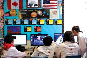 Members of the RMOC Group at St. John Paul II School in Bolton, Ont., are taking part in a cross-border project that will connect them with a satellite sending photos of the Earth as well as schools in the United States. Canadian astronaut Jeremy Hansen, right, visited the school in early April to inspect the communications centre and speak to students about his journey to space.