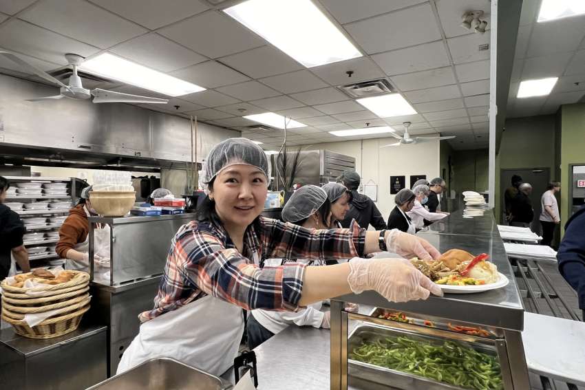 A volunteer at Good Shepherd Ministries provides a plate of turkey, potato, vegetables and stuffing to be served at this year’s Easter meal service.