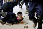 An anti-government protester is detained by riot police in Hong Kong, China Oct. 27, 2019. As protests pitting pro-government groups against pro-democracy protesters continue, a bishop urged Catholics to pray for the realization that all are humans and not &quot;cockroaches or dogs.&quot;